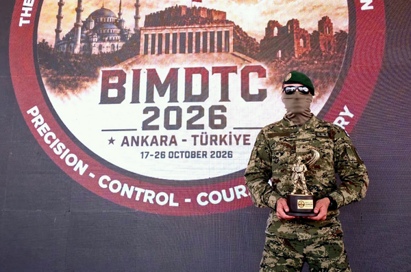 Croatian military drone operator in uniform holding a trophy in front of the BIMDTC 2026 competition backdrop in Ankara.