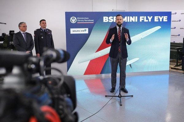 Polish military personnel and officials attending the Blue Eye-26 drone exercise in Nowy Glinnik, with unmanned aerial systems displayed in the foreground.