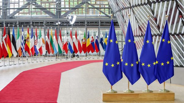 European Union and member state flags inside the Council of the EU's Europa building in Brussels.