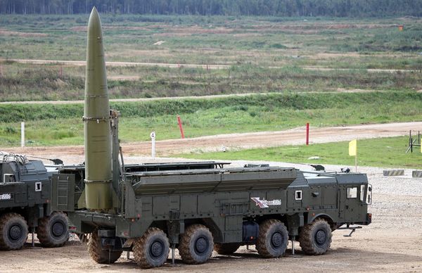 Russian Iskander-M mobile ballistic missile launcher with a raised missile at a military demonstration.
