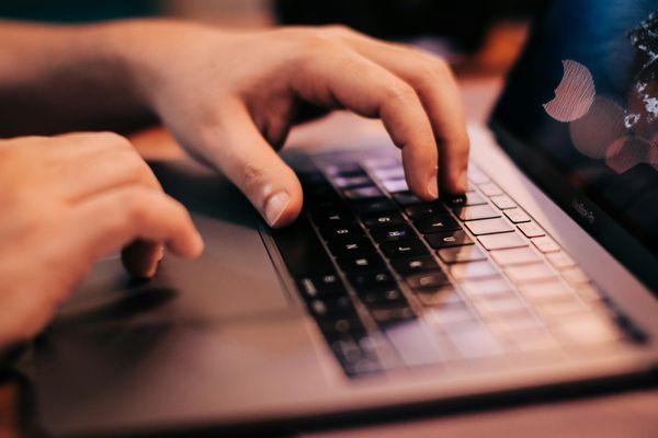 hands typing on a laptop