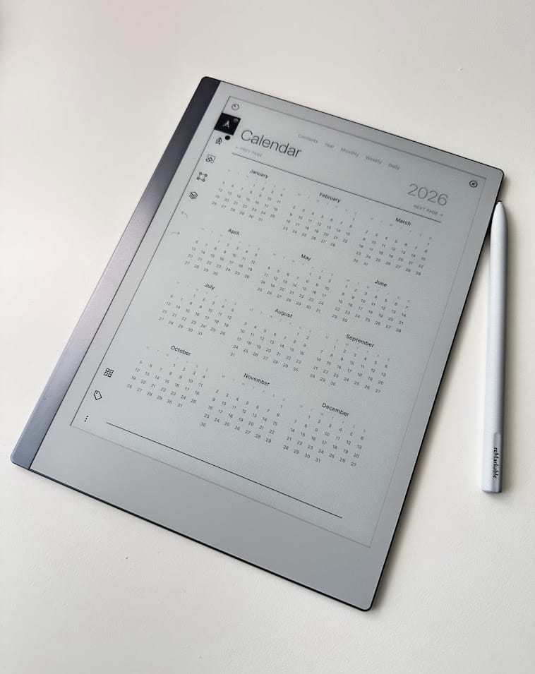 Photo of a reMarkable tablet displaying a custom interactive calendar template for 2026 alongside a stylus pen on a white surface.