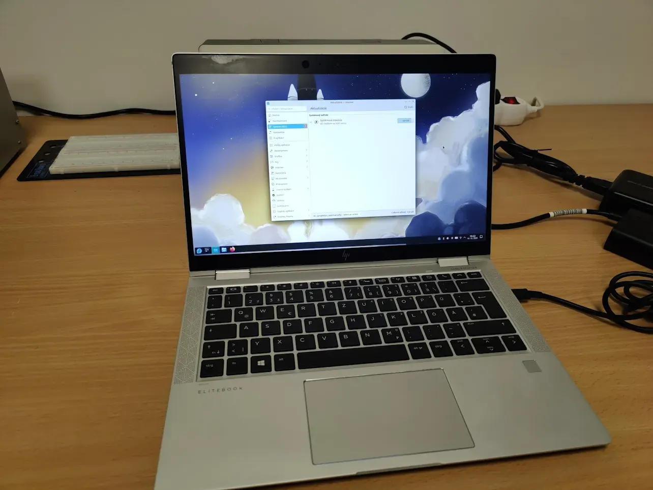 HP EliteBook laptop running Fedora Linux on a desk.