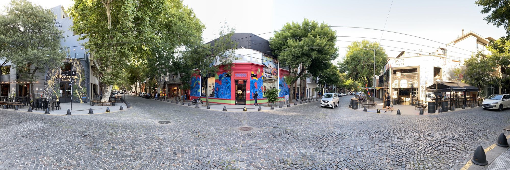 An intersection in Buenos Aires with colorful houses and a cobblestone street