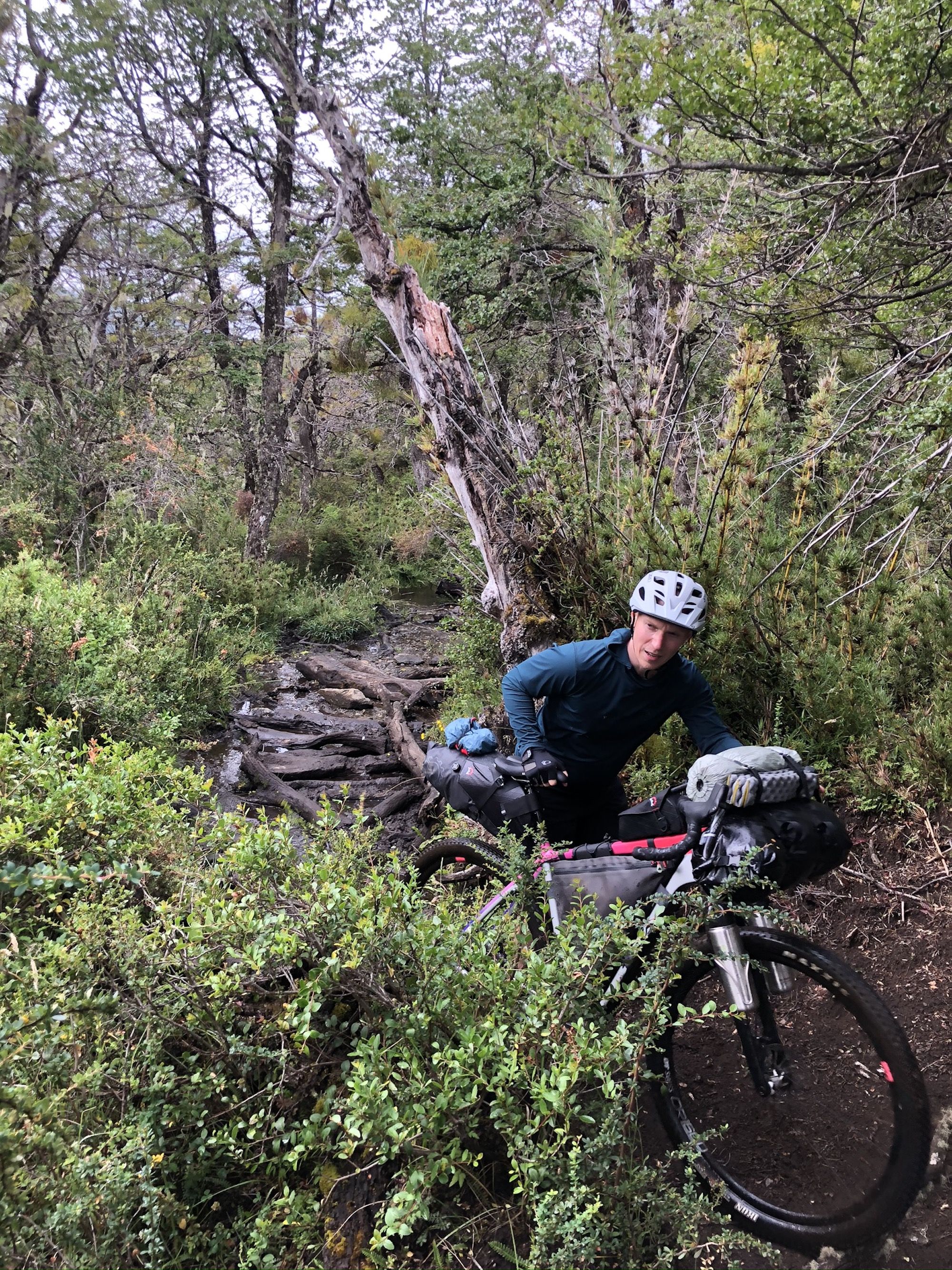 Man pushing his bike through mud