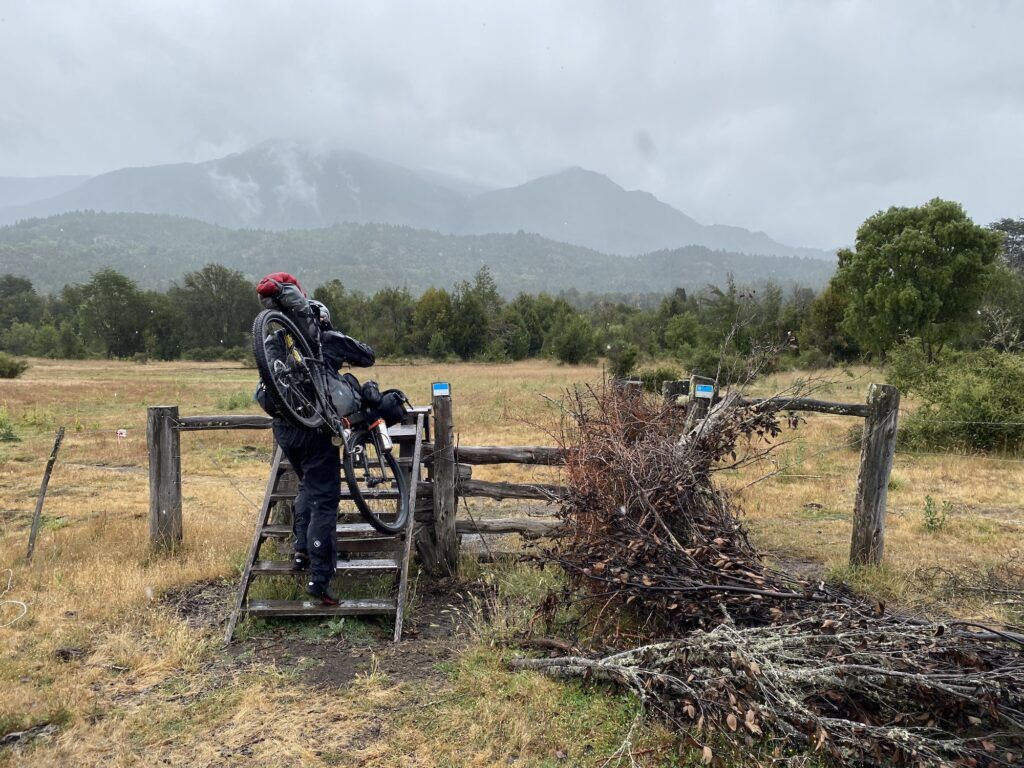 Man carrying a bike on stairs over a fence