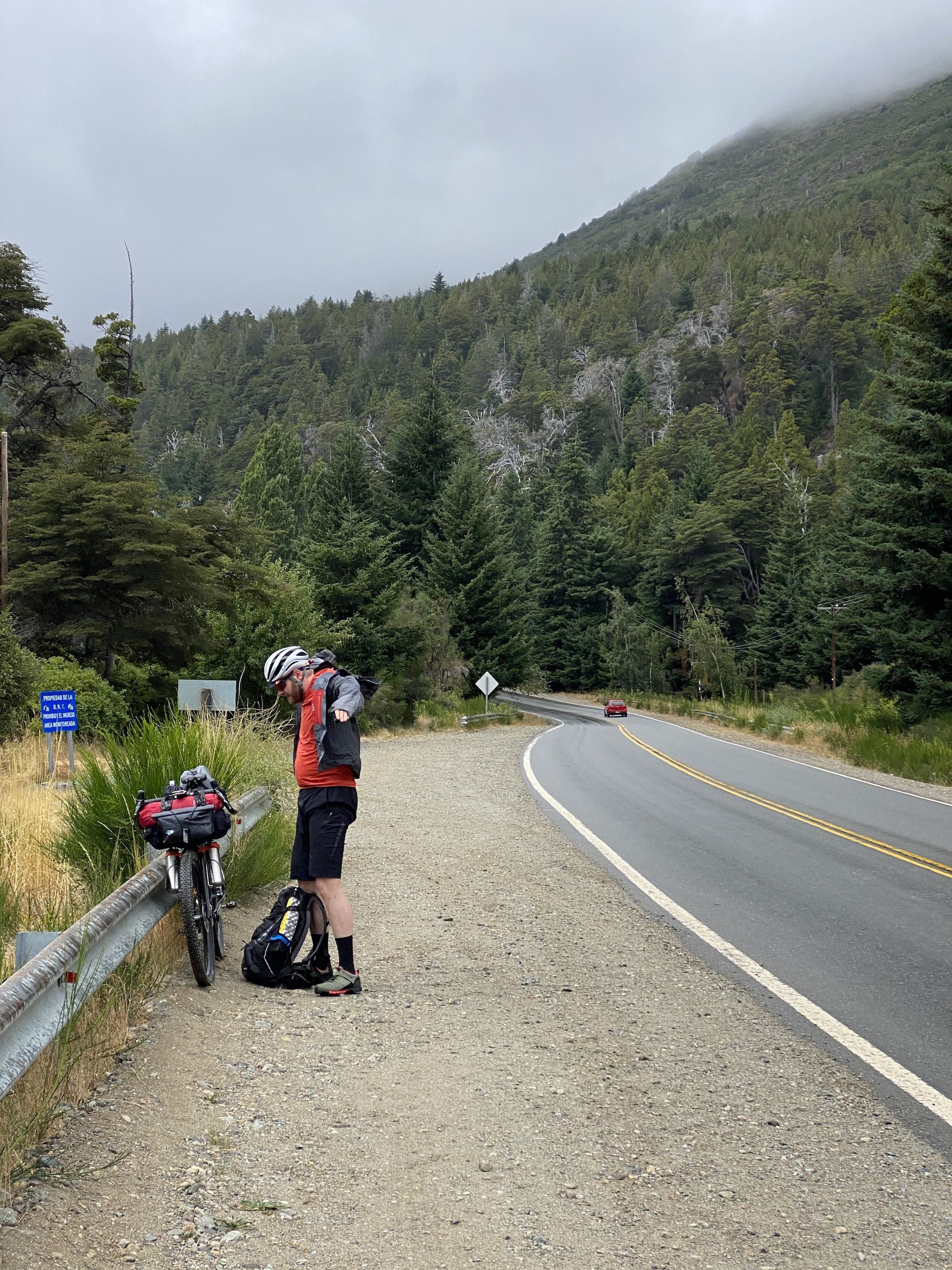 A man putting on a rain jacket