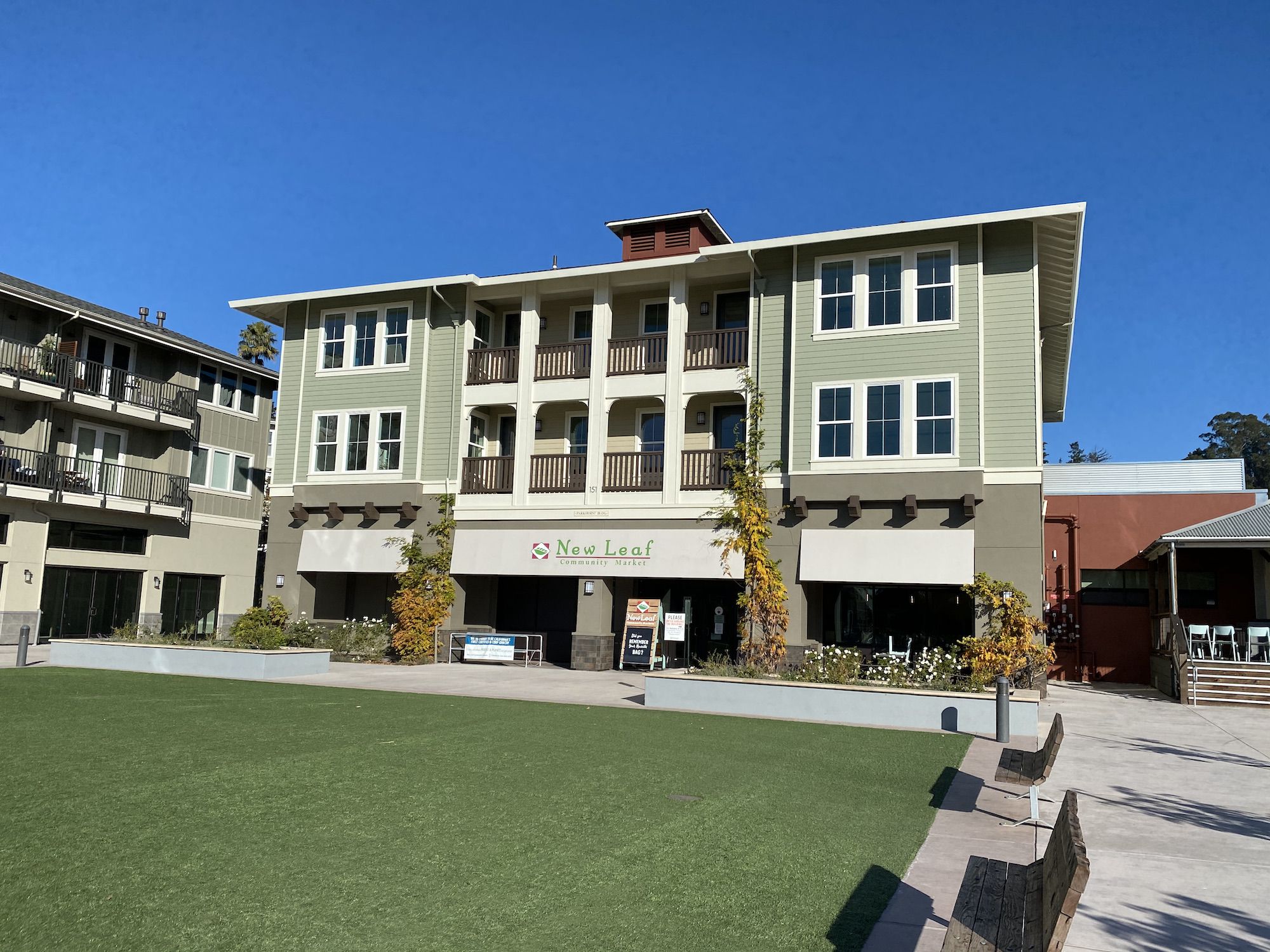 A courtyard with a lawn surrounded by benches. 