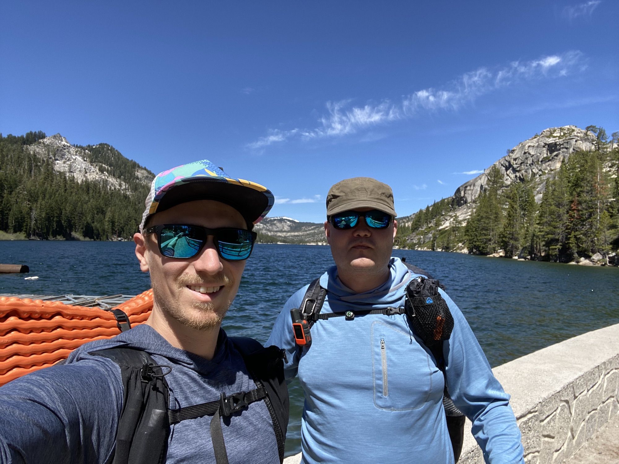 Two men with backpacks standing in front of a lake. Starting our backpacking trip into Desolation Wilderness.