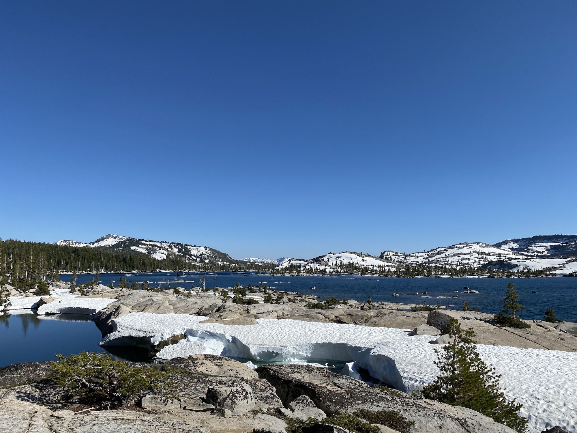 A blue lake surrounded by snowy mountains
