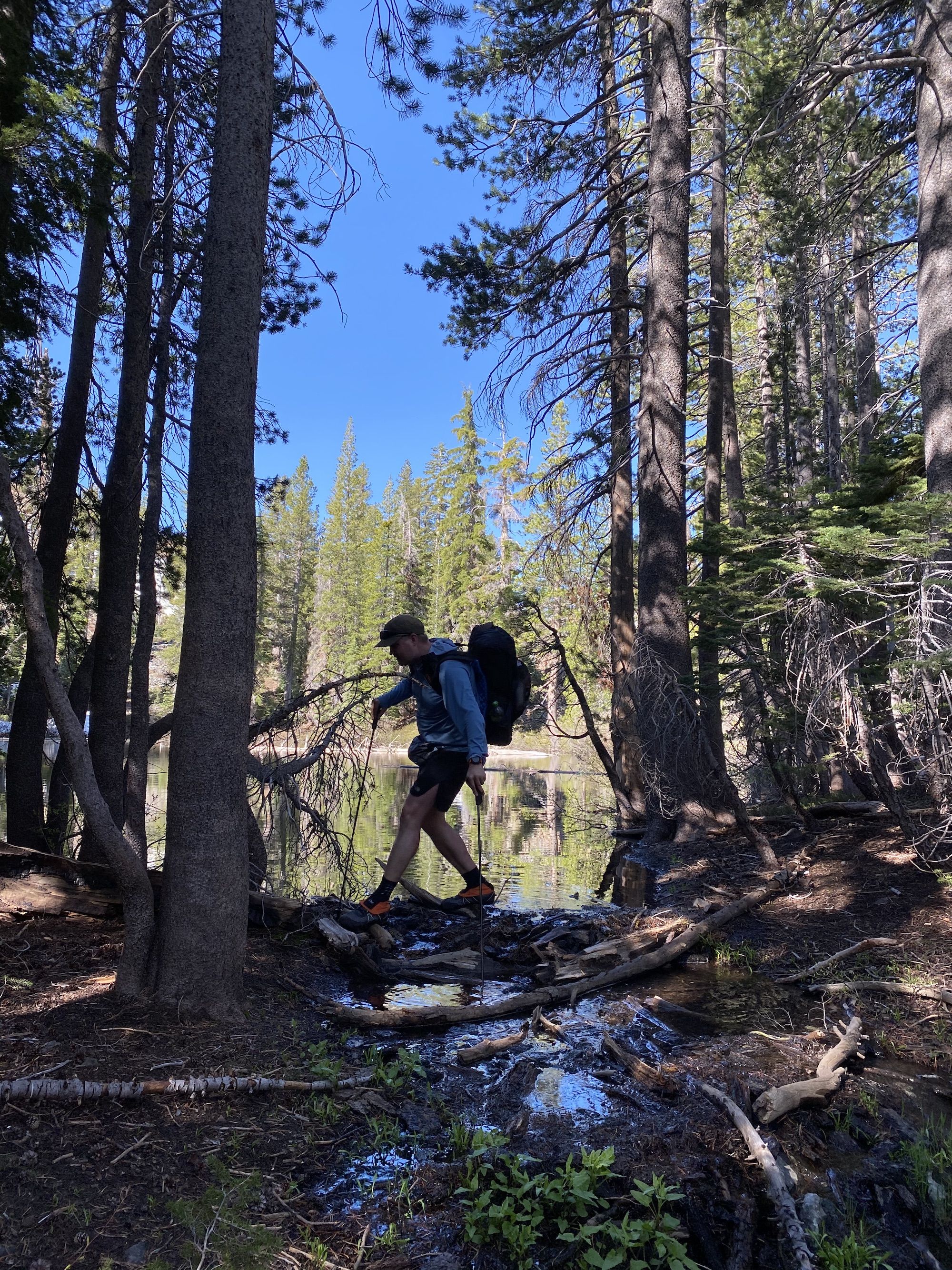 A man crossing a stream on a log