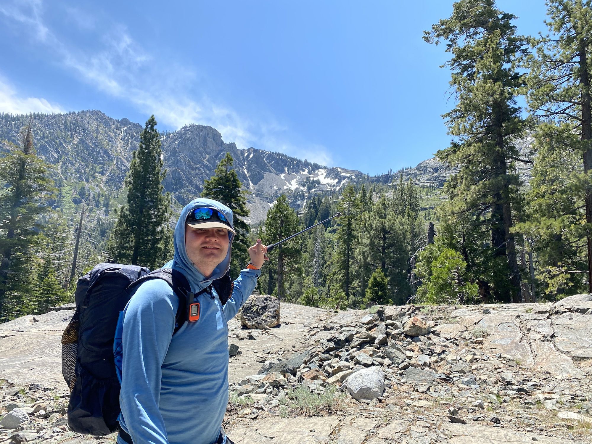 A man pointing toward a mountain pass