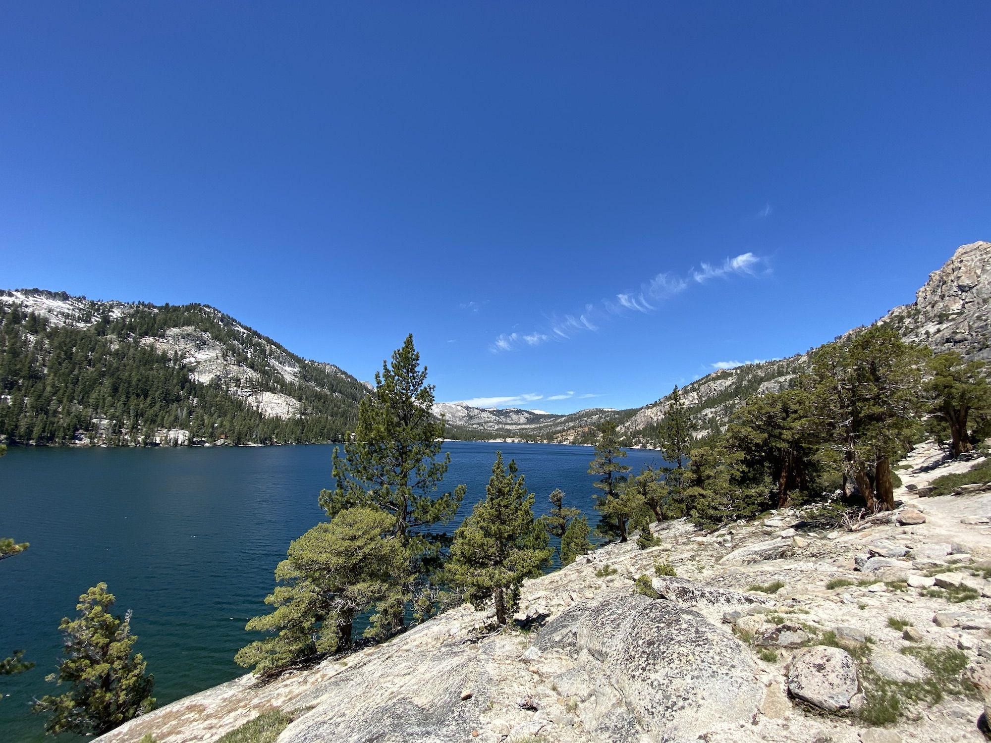 A rocky shoreline and a blue lake