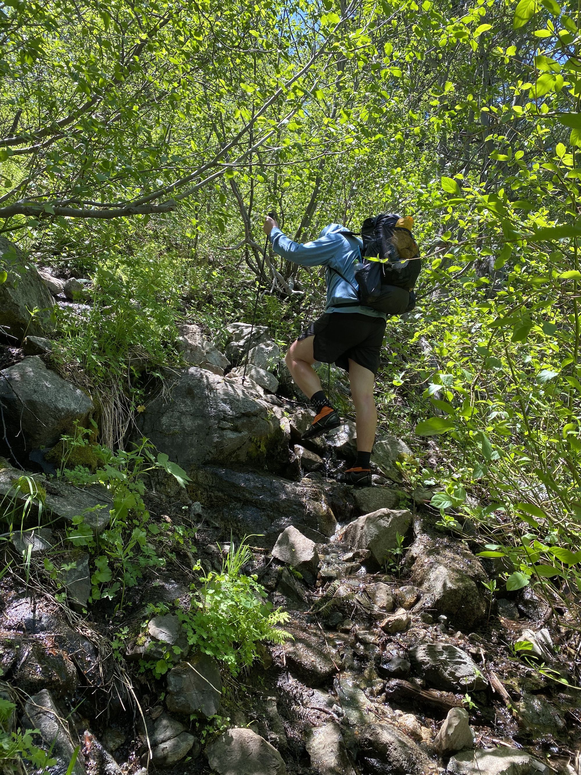 A man climbing up a steep rocky trail