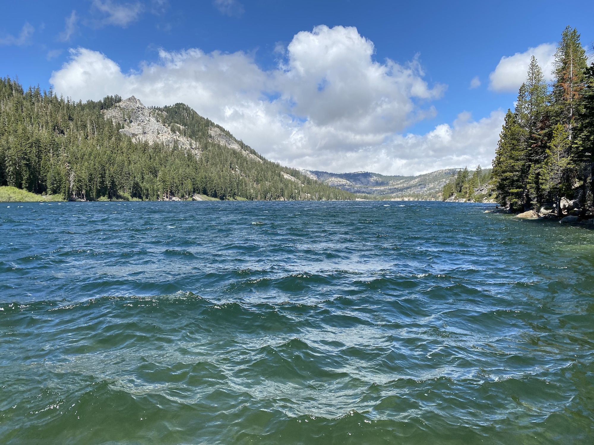 A blue lake with mountains behind