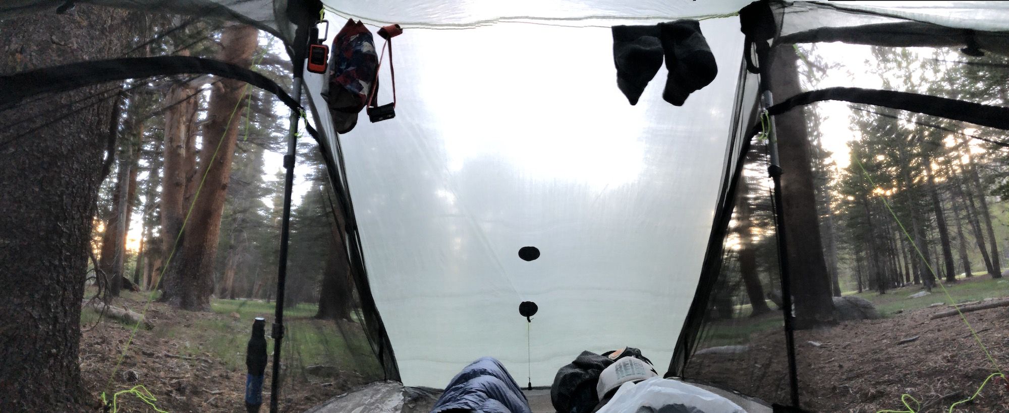 The inside of a tent. It is still light outside.