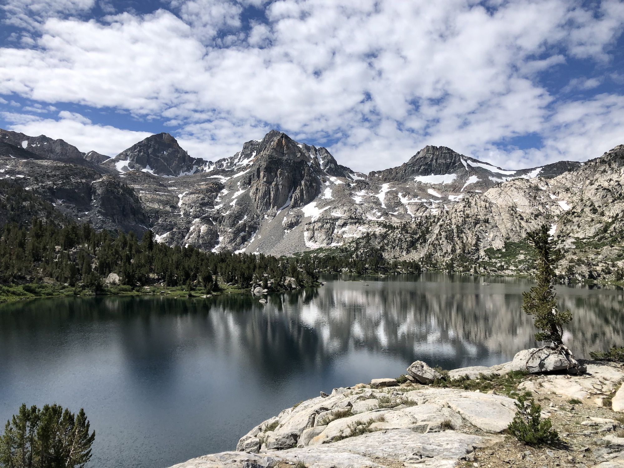 A lake reflecting the snowy mountain peaks behind it