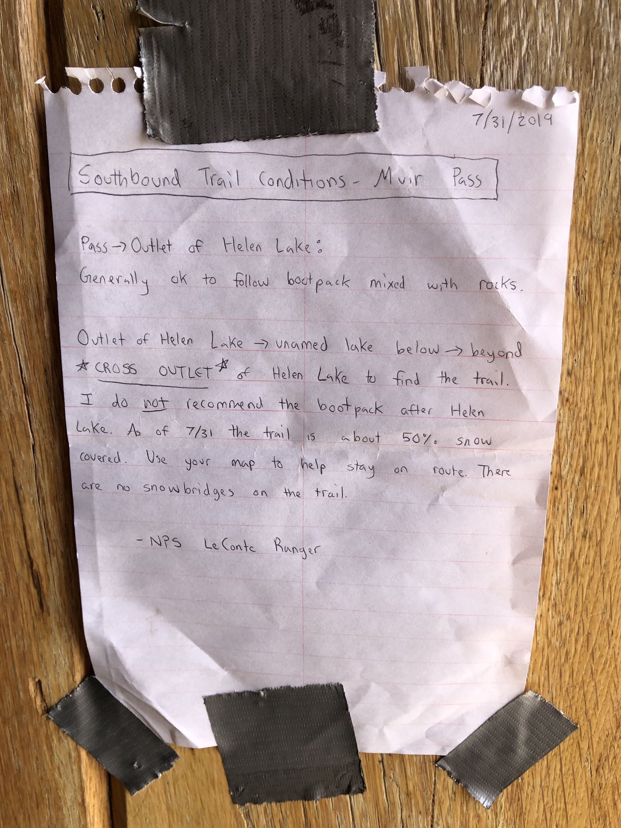 A note telling hikers not to follow old boot tracks through the snow