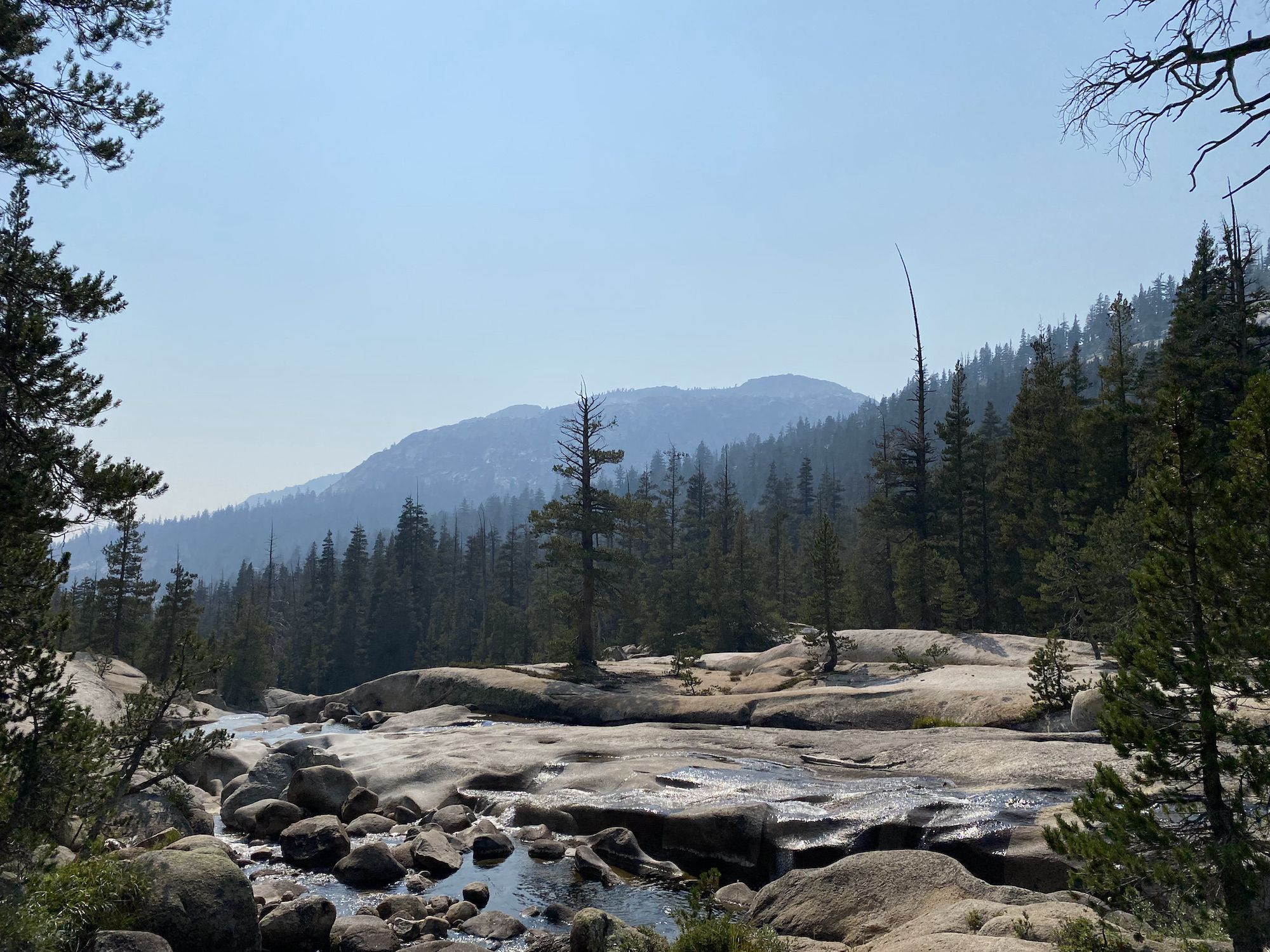 A creek flowing over a polished smooth rock surface. 