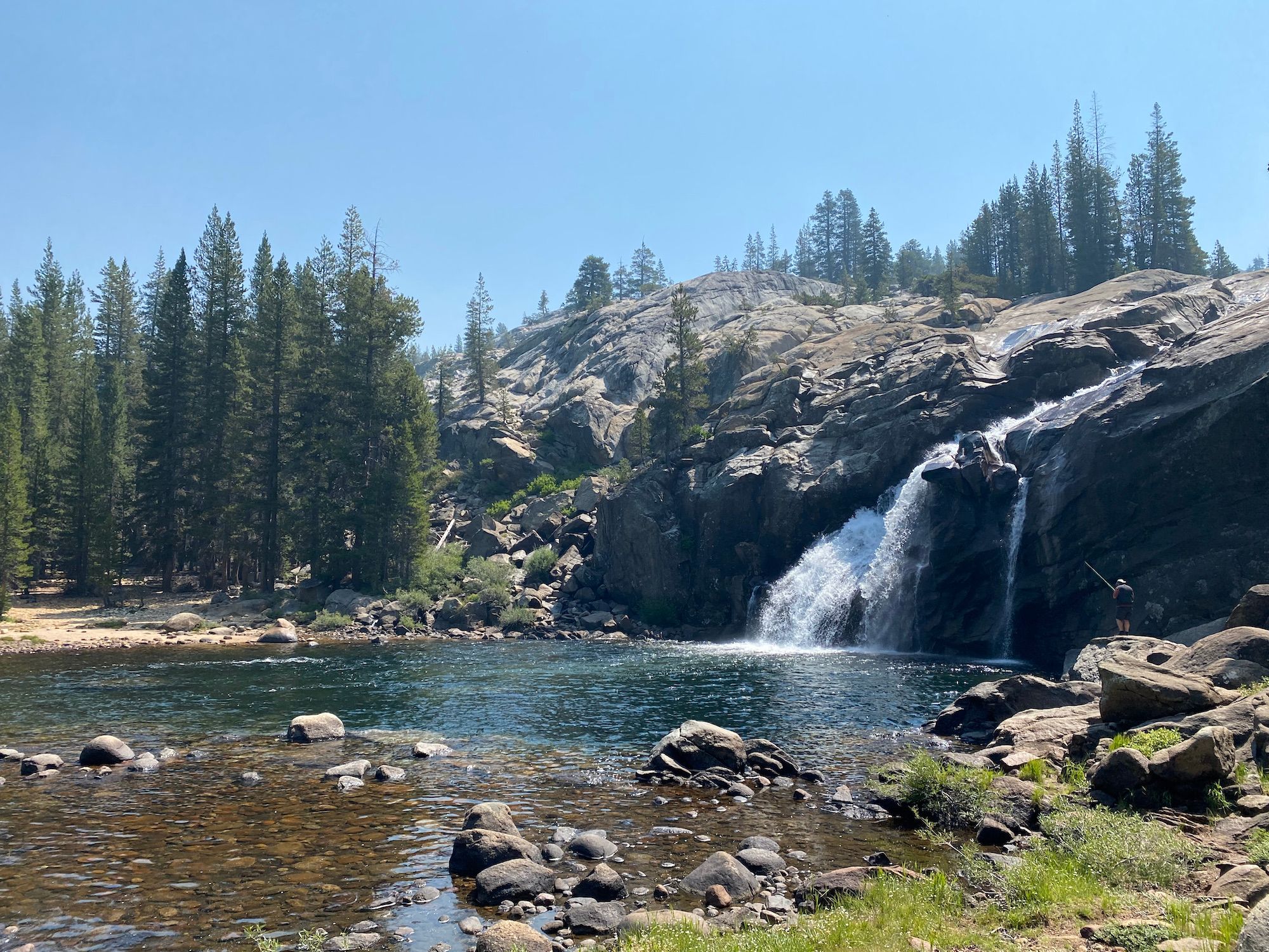 A waterfall dropping into a deep pool of water.