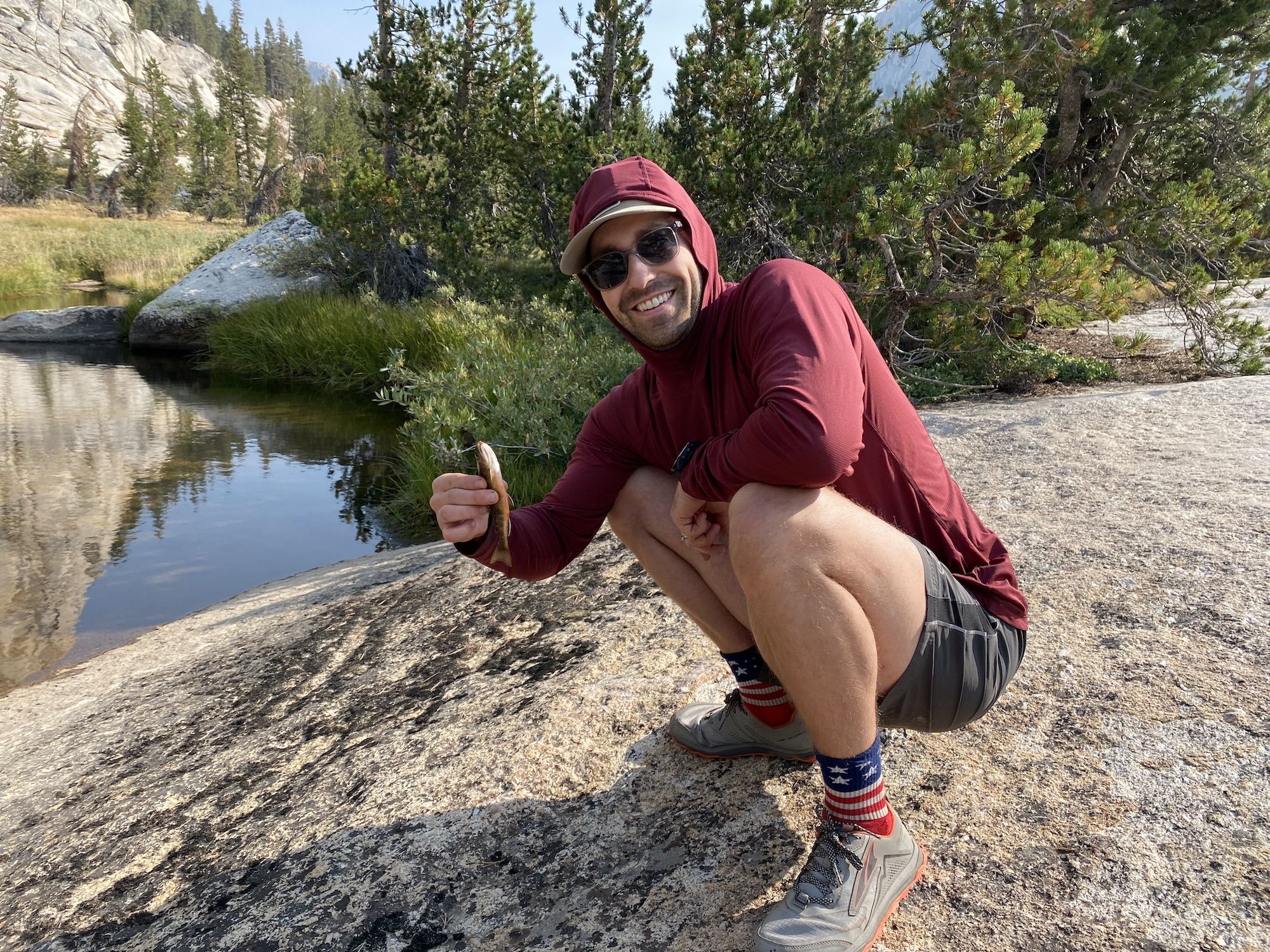 A man holding a tiny fish.