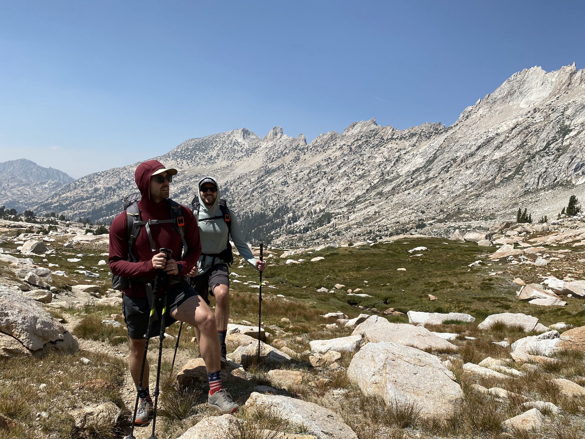 Two hikers in front of a mountain range.