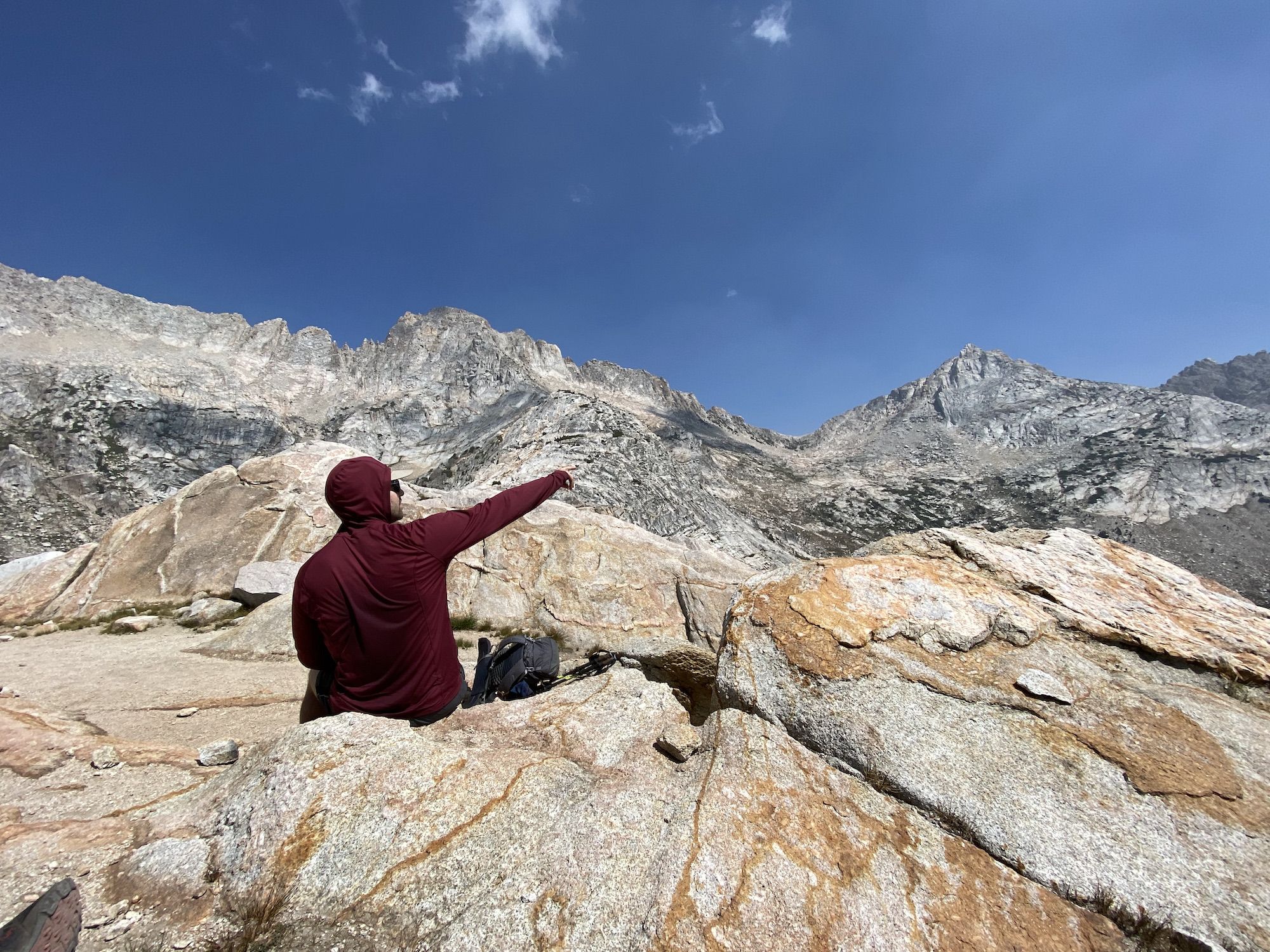 A man pointing at a mountain pass.  
