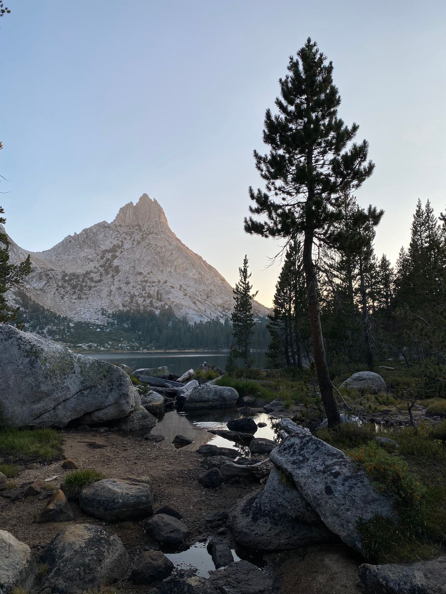 A tall mountain peak illuminated on one side by the last soft light of the setting sun.