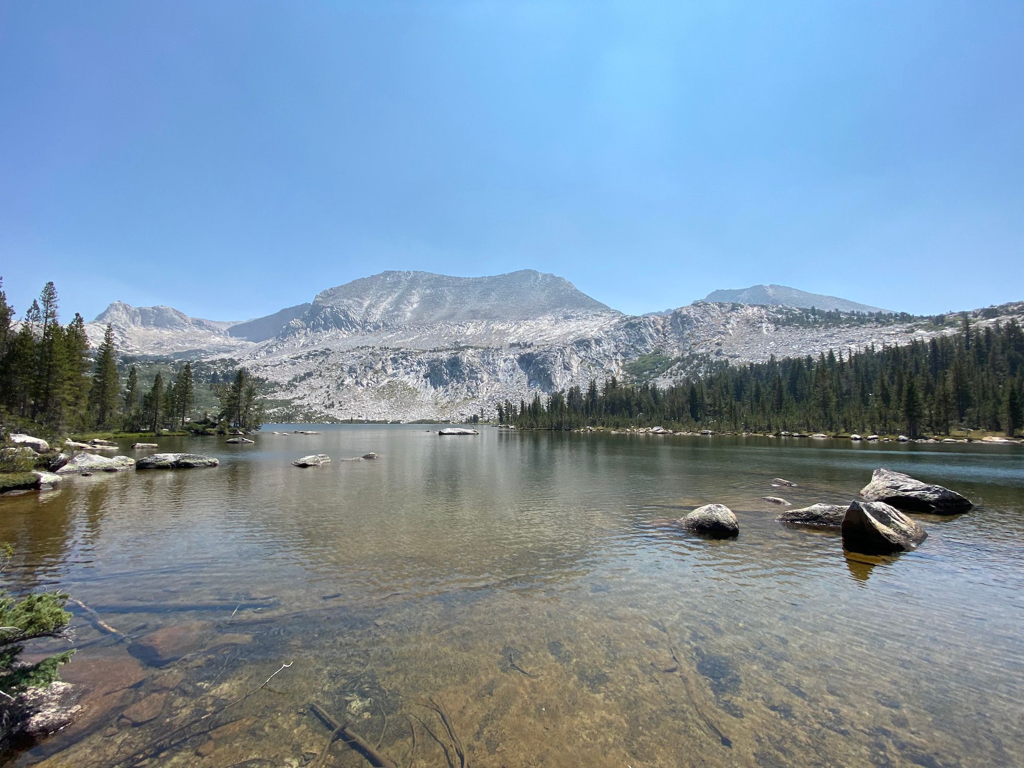An alpine lake surrounded by mountain peaks and pine trees.