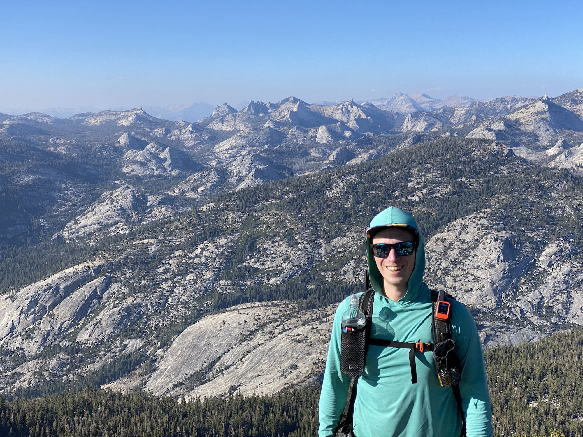 A man standing in front of a wide mountain vista.