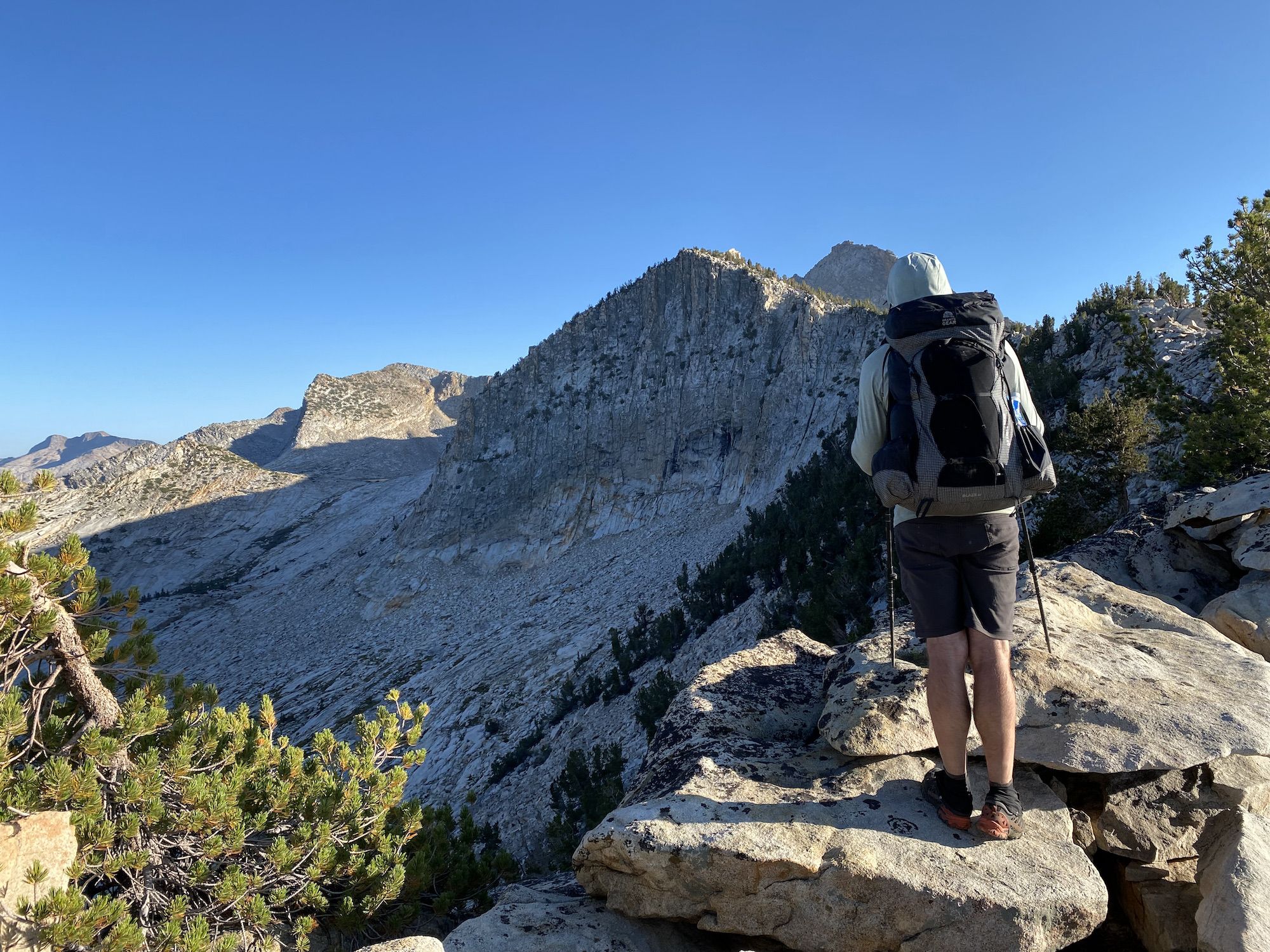 A backpacker looking at a steep mountainside.