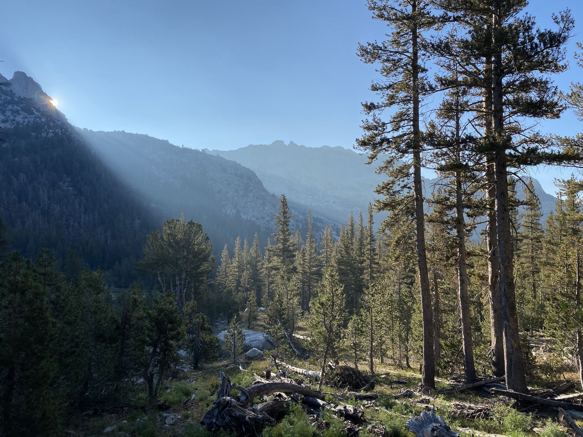 The sun peeking out behind a mountain.