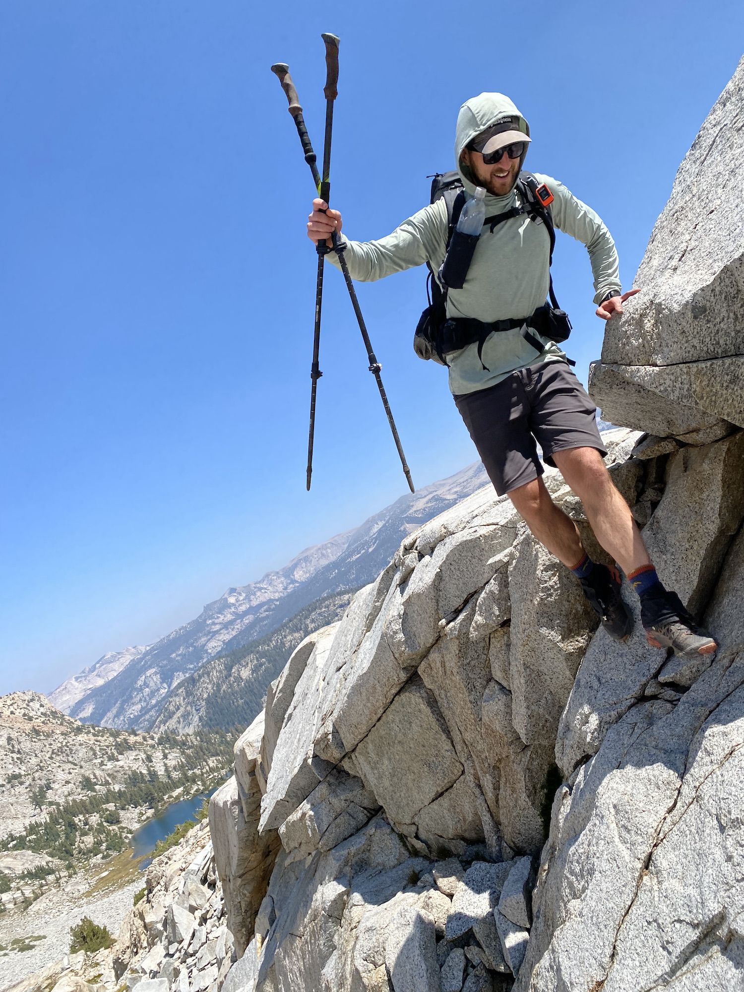 A backpacker coming down a steep rocky wall.