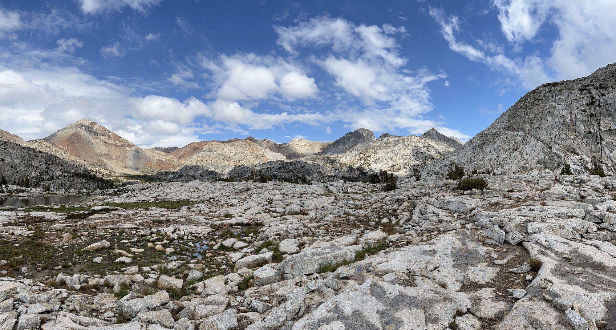 A rocky mountain landscape under a blue sky with a few white clouds.