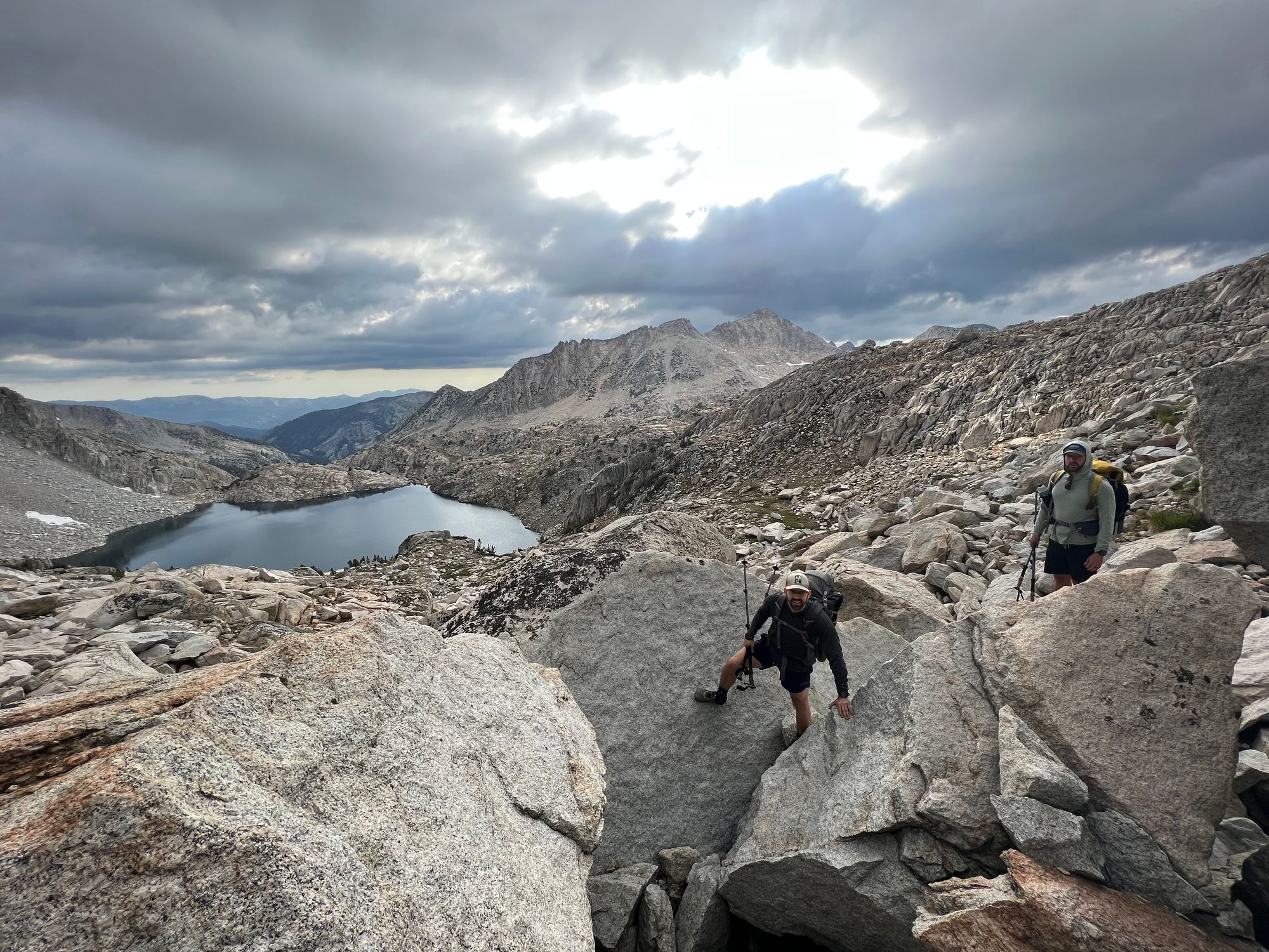 Two backpackers on car-sized rocks.