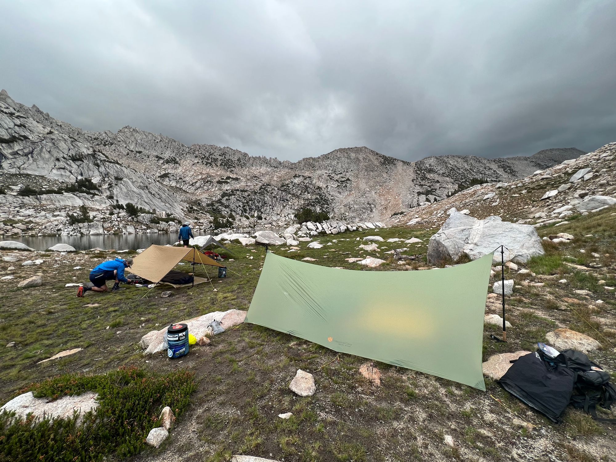 3 tarps set up near a lake