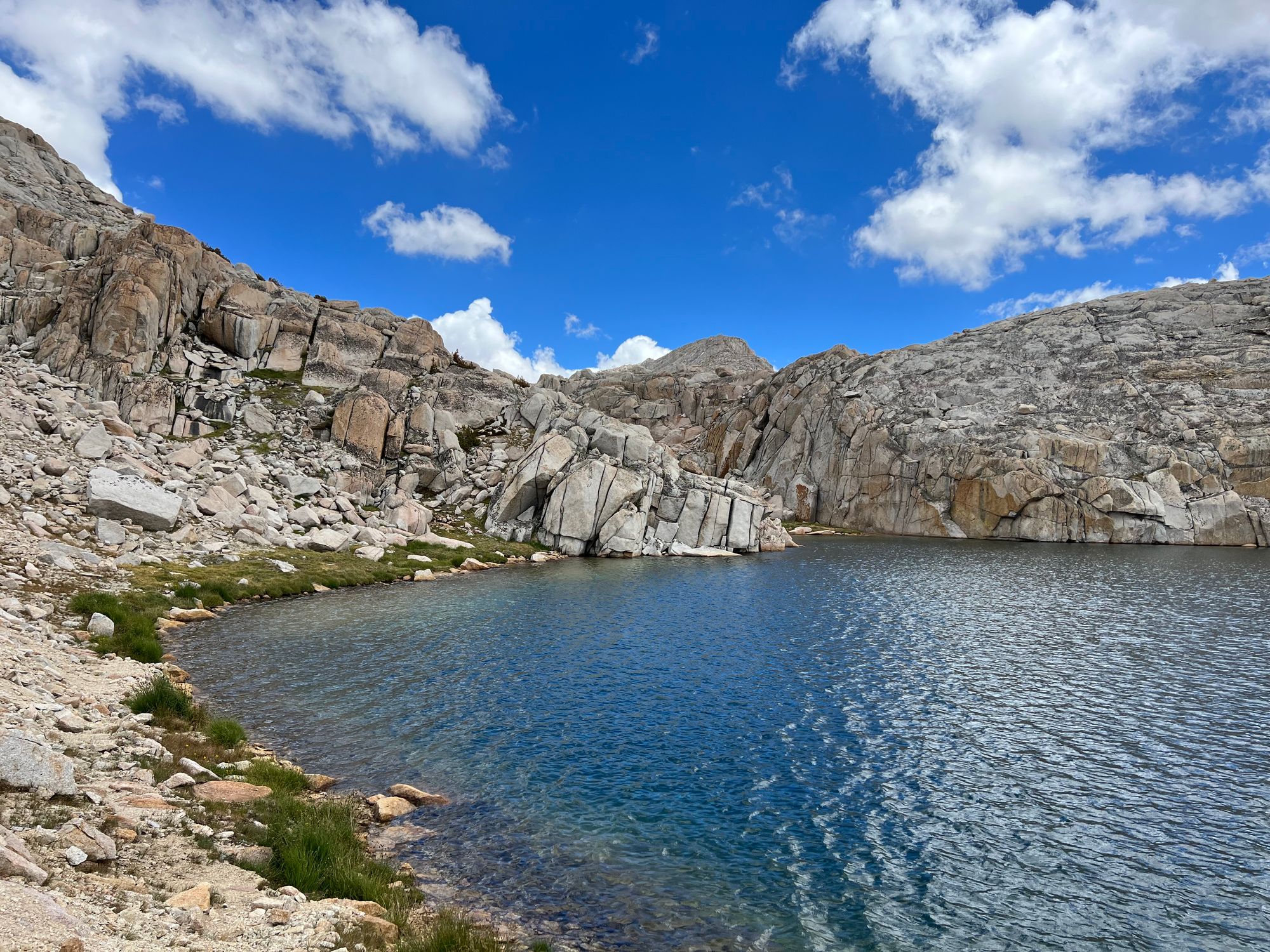 Steep granite rocks on the shore of a lake.