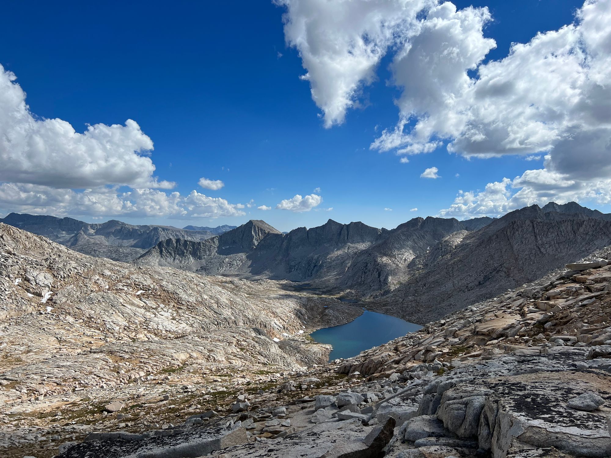 A rocky mountain ridgeline with a lake far below. 