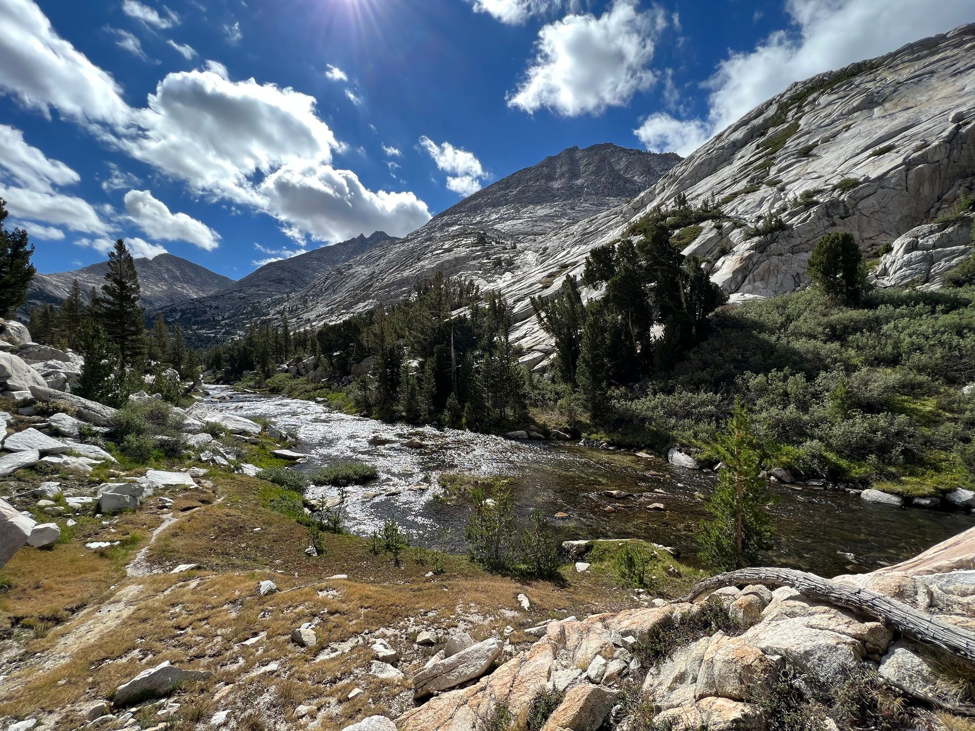 A wide creek flowing through a mountain valley.