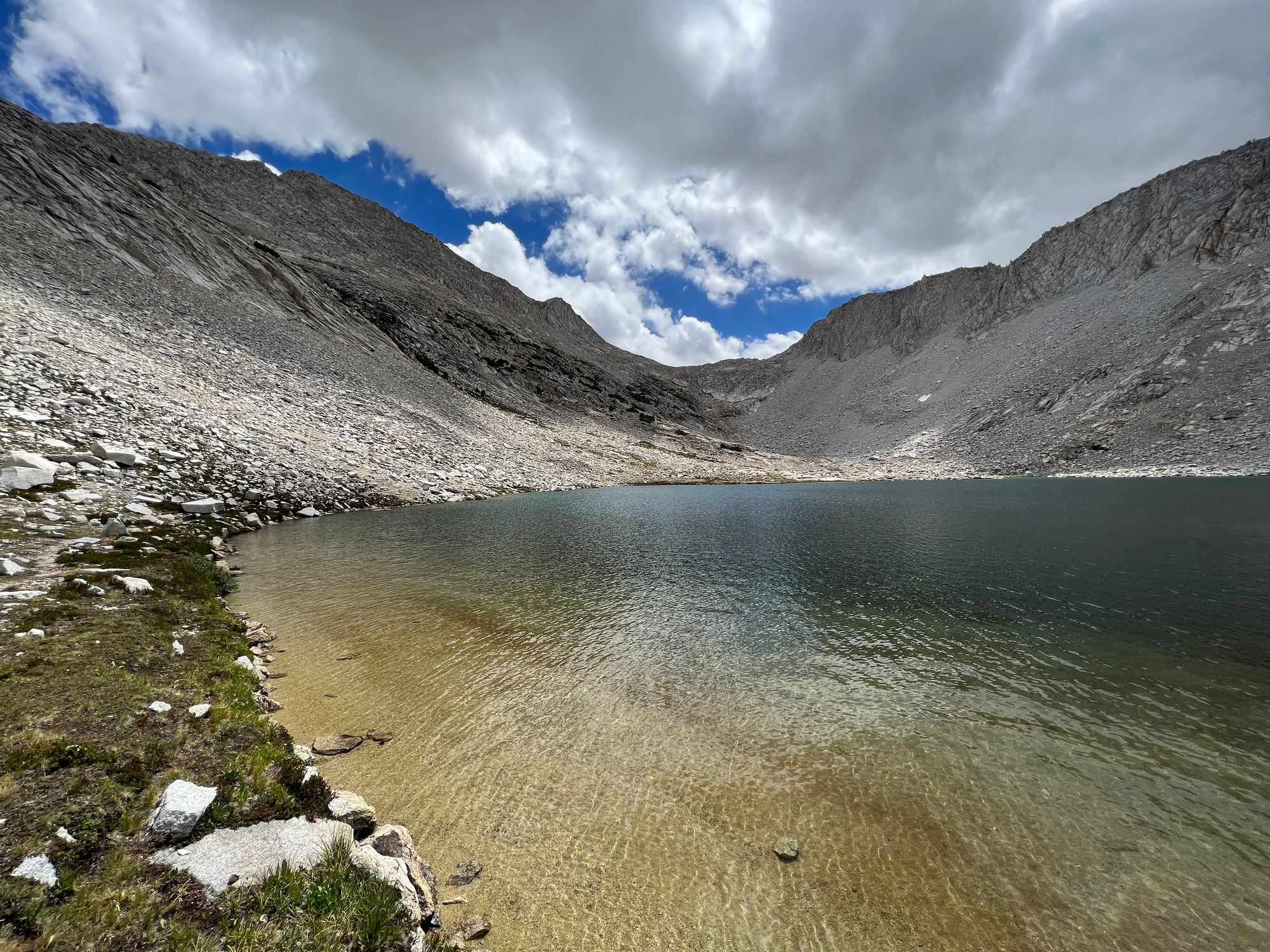 A rocky mountain pass on the other side of a lake.