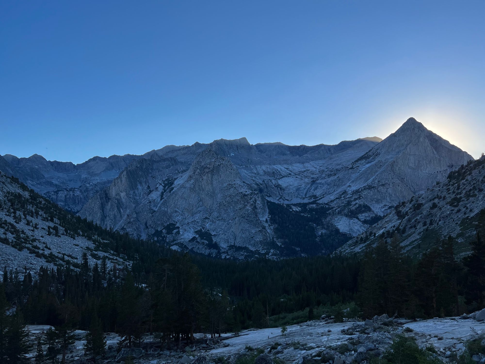 Sun rays visible behind a mountain peak.