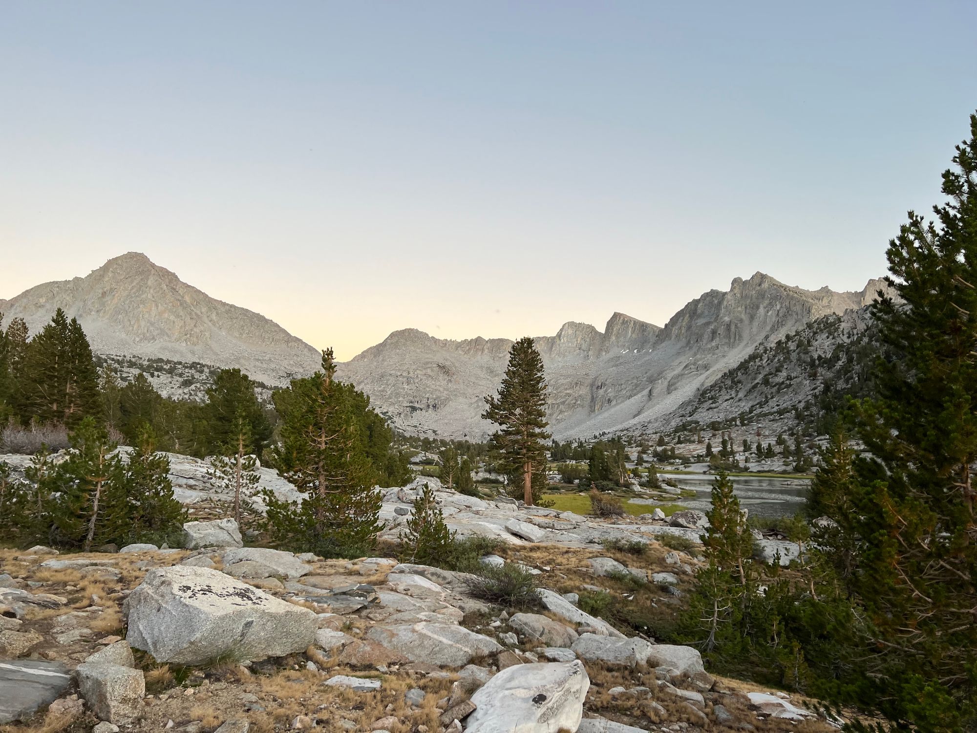 Dusk light illuminating a basin with a small lake.