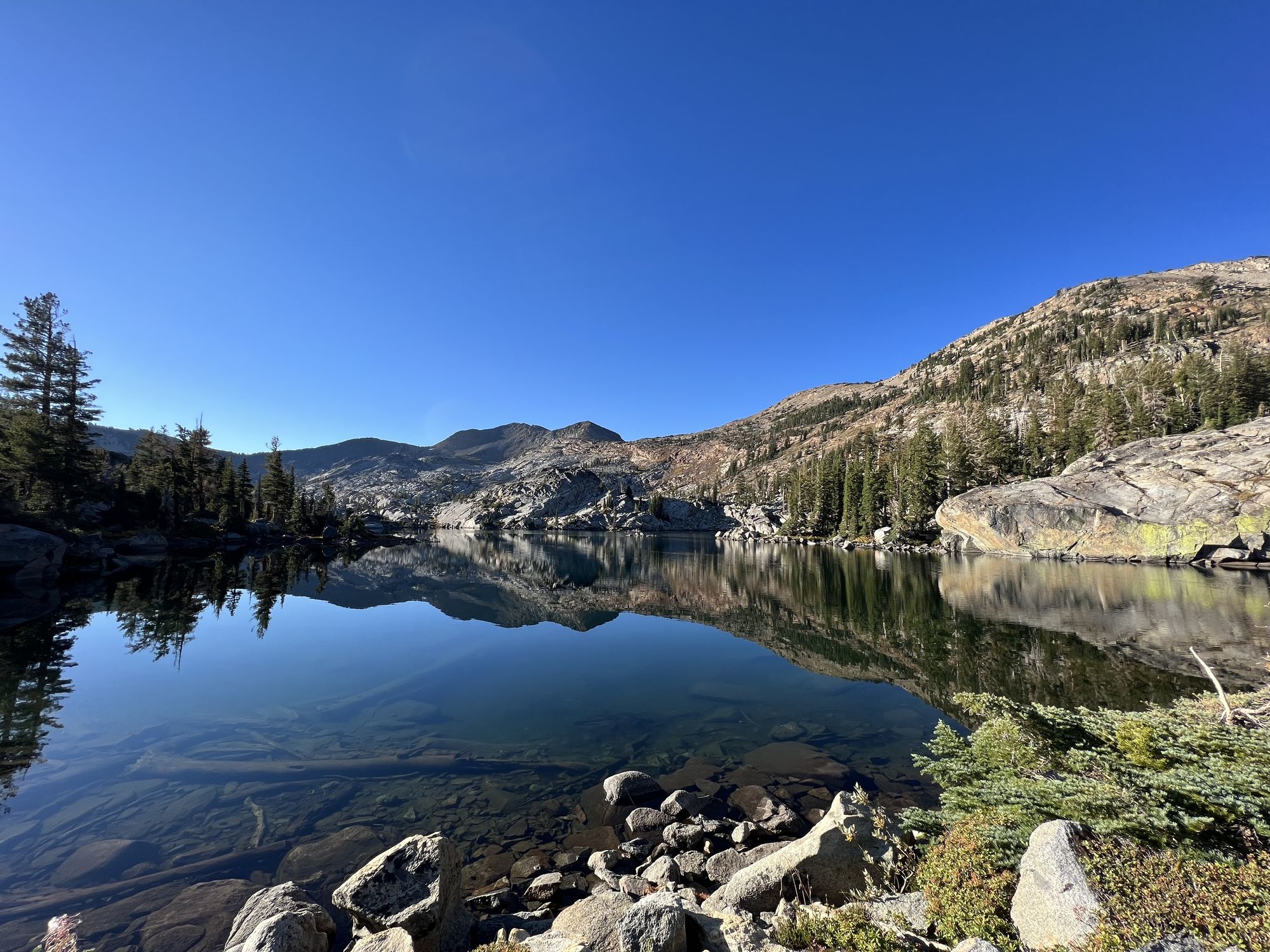 An alpine lake reflecting mountains on the other side.