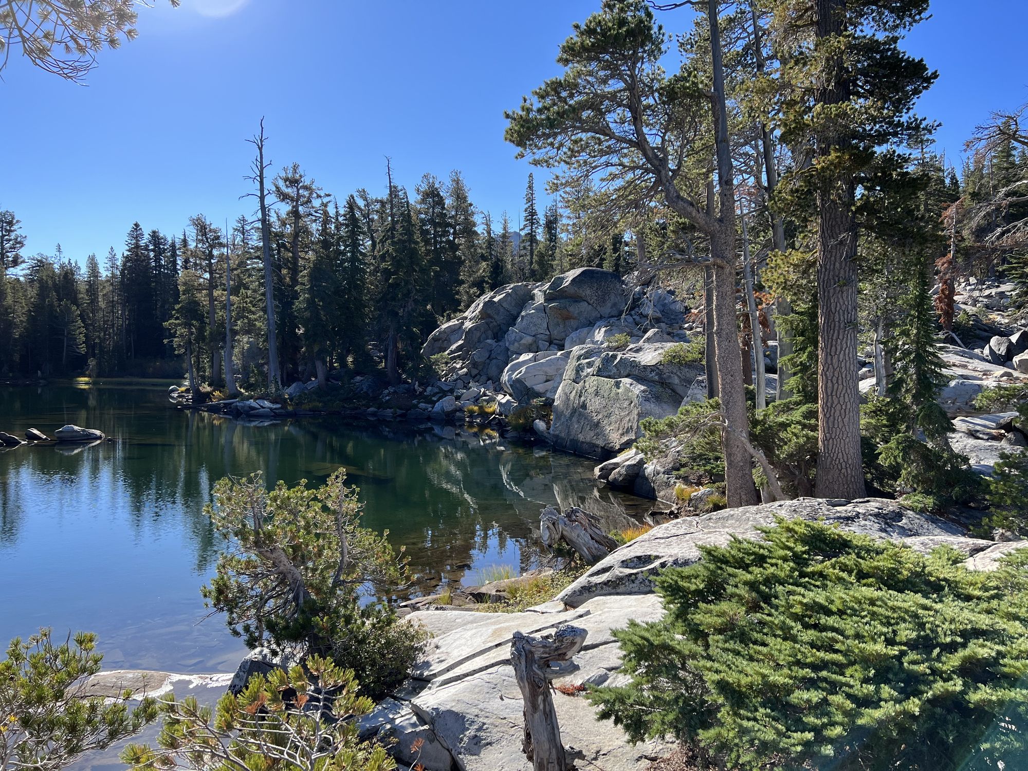 A near-vertical rock wall leading into a lake.