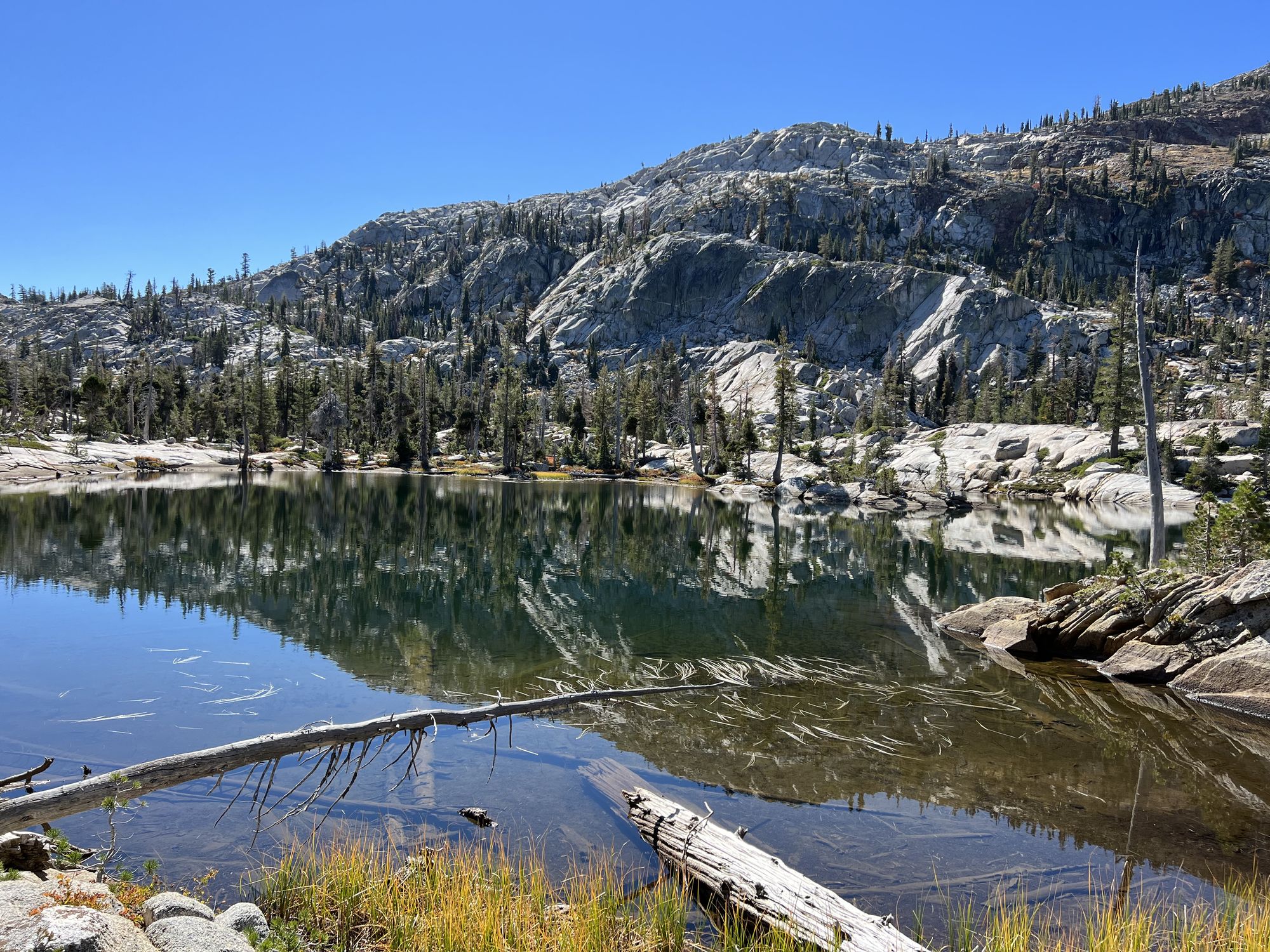 A small lake with a steep rocky hill on the other side.