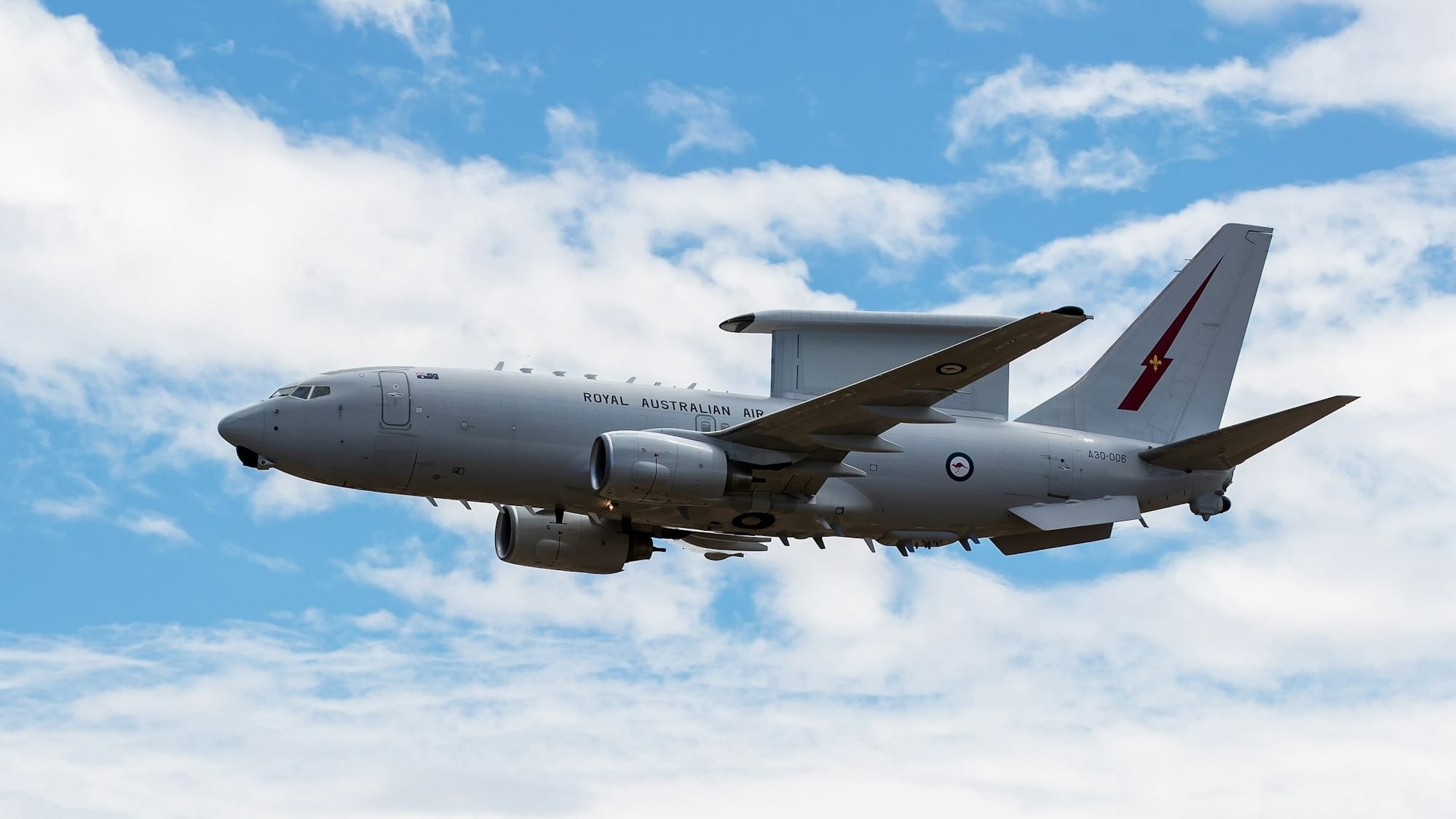 A military aircraft flying in a cloudy sky
