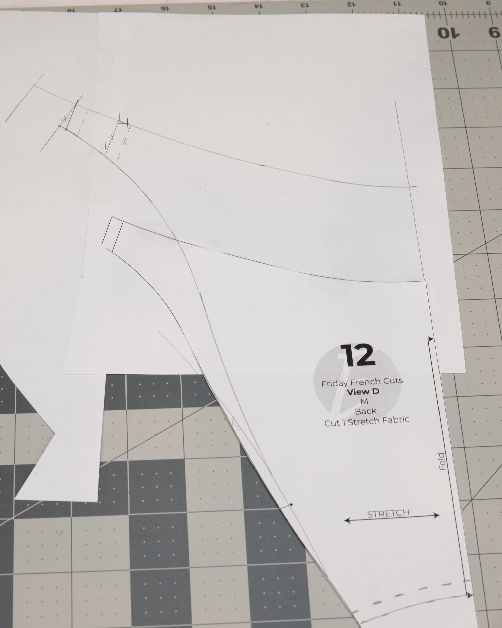 original back sewing pattern piece with lines drawn on paper to create a new pattern piece