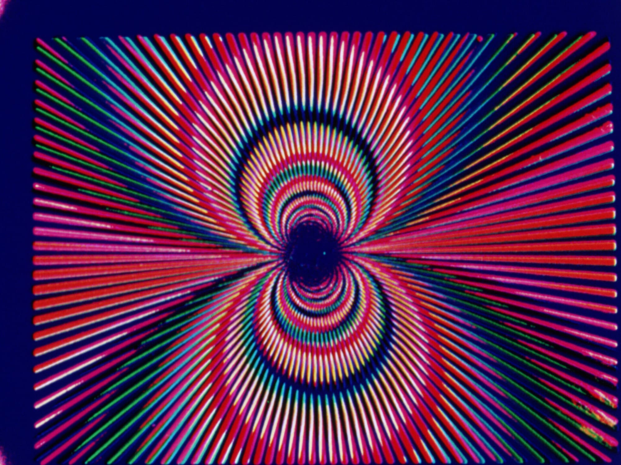 A colorful, abstract pattern made up of concentric circles and lines.