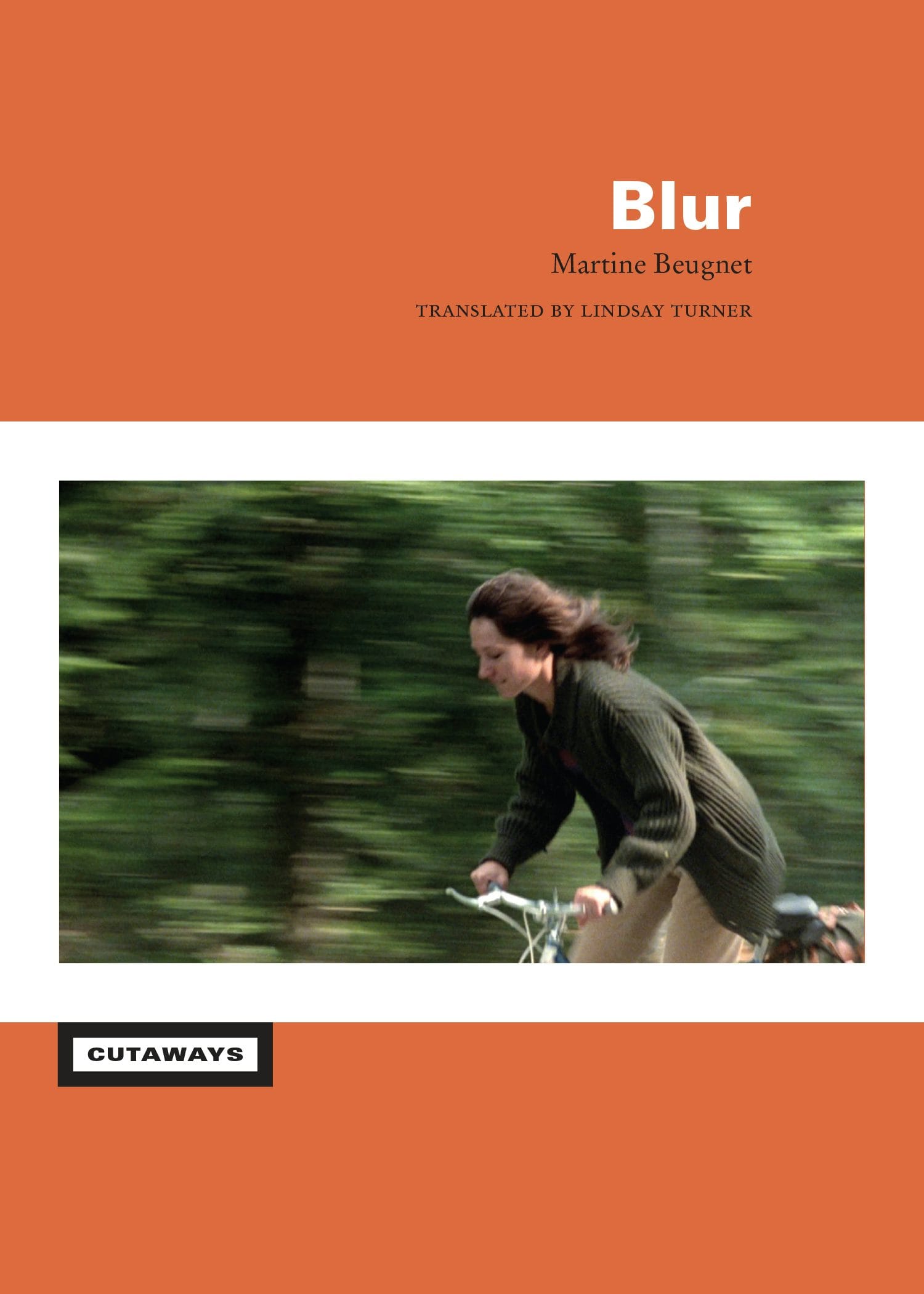 The cover of the book Blur, with a woman in a green sweater riding a bicycle against a blurry background.