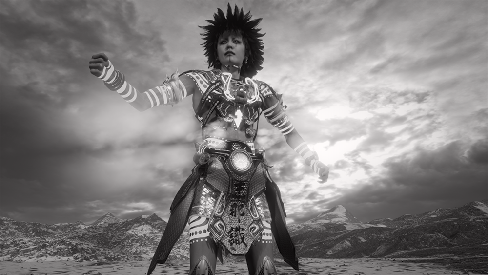 A CGI-rendered black and white image of an avatar dressed in ornate warrior gear standing in a snowy, mountain environment with a cloudy sky in the background.